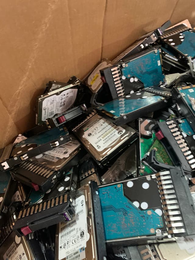 A box filled with hard drives placed on a table, showcasing various storage devices for data management.