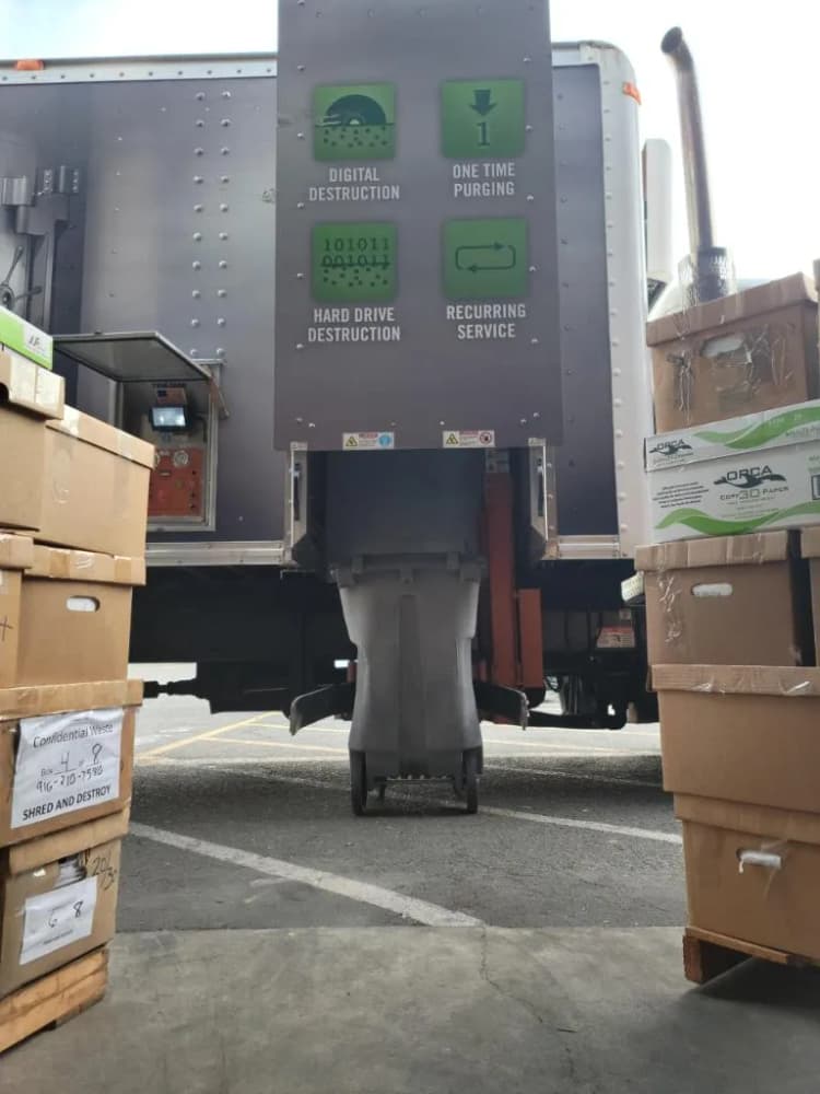 A parked truck positioned before a collection of boxes, likely for transport or storage purposes.