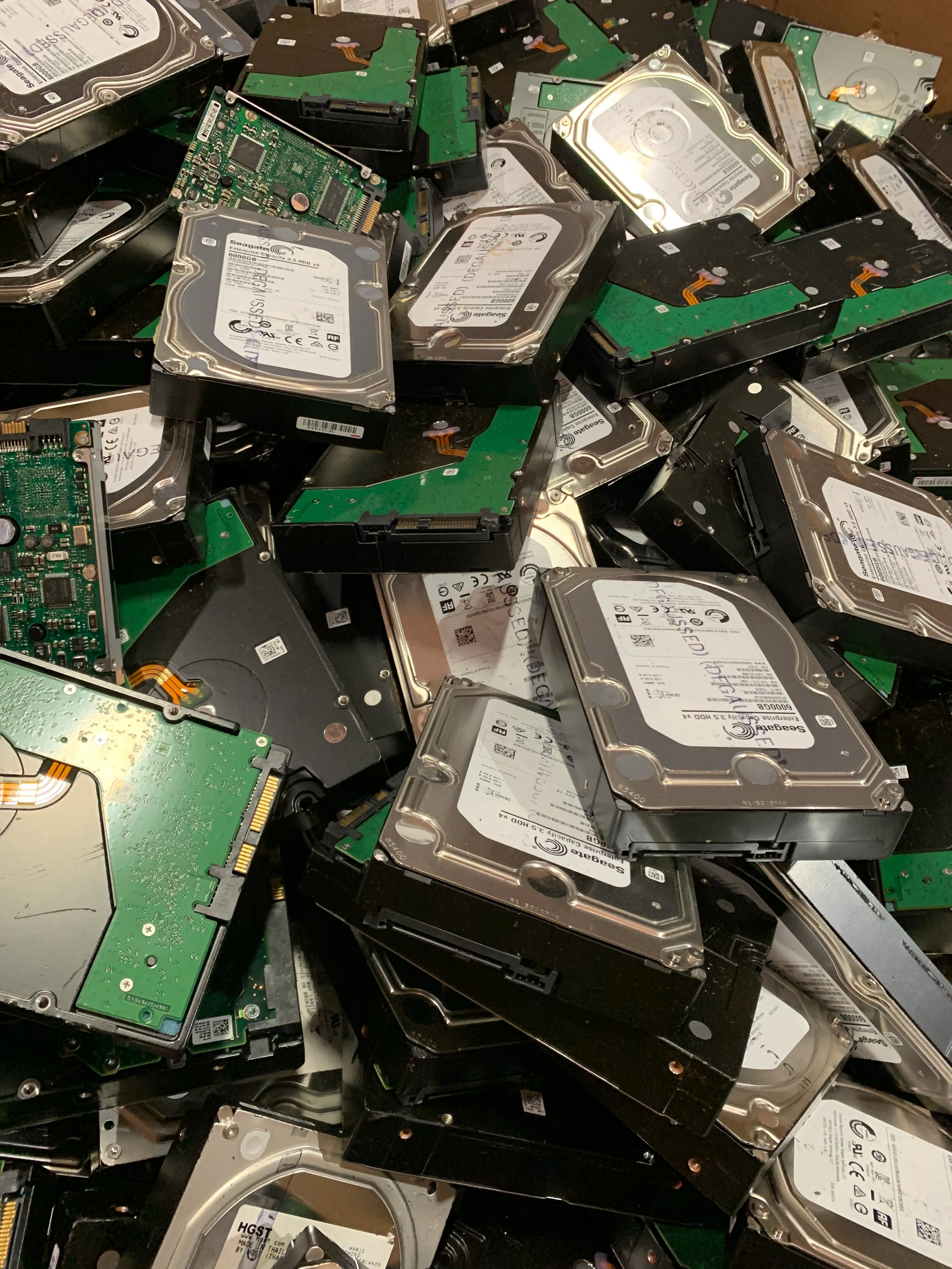 A collection of hard drives arranged in a pile, highlighting their different designs.