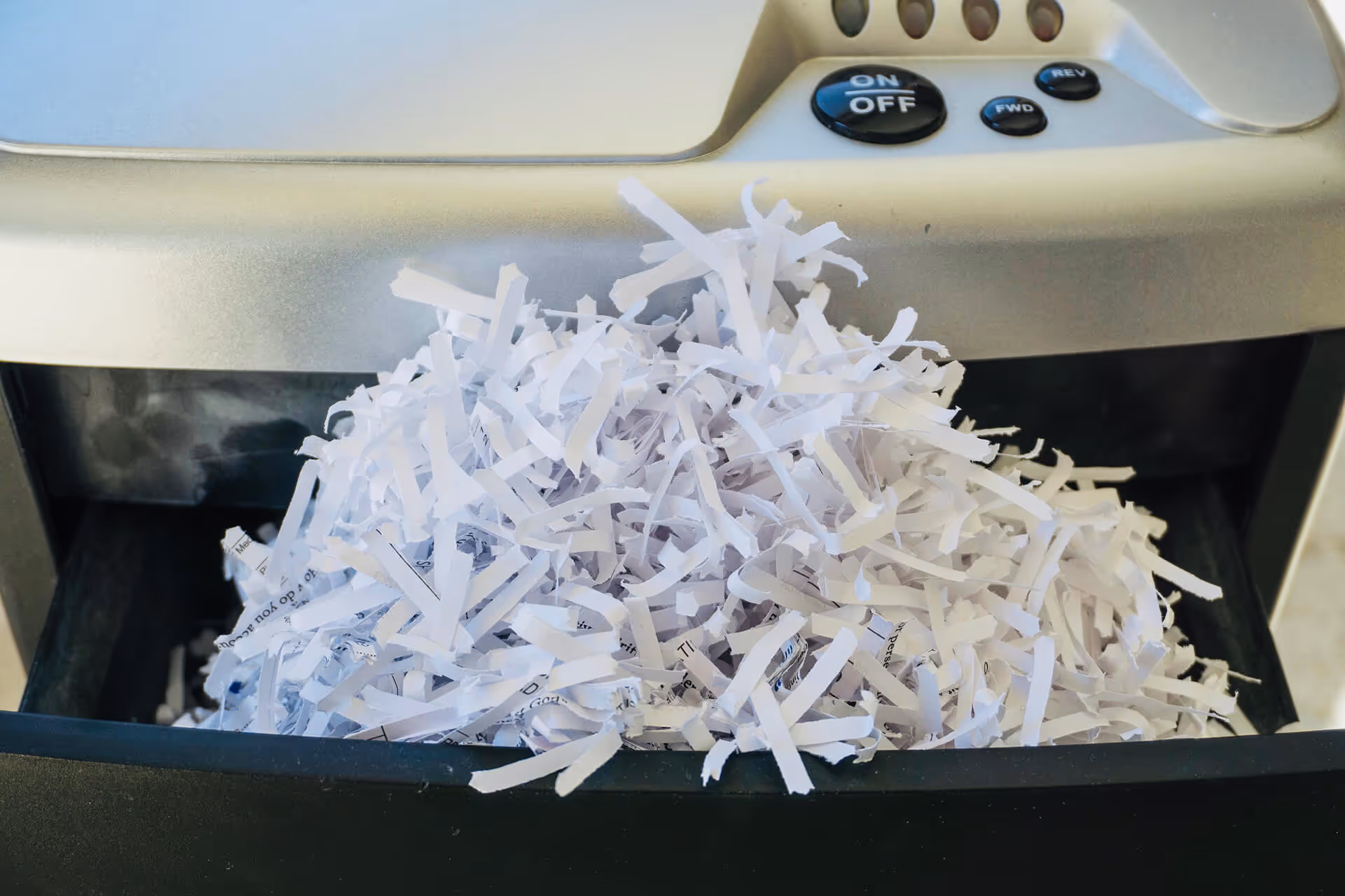 shredded paper bulging out of a paper shredder