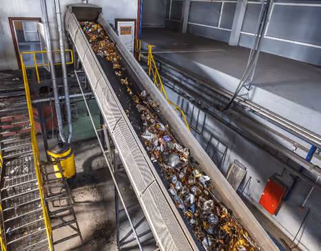 conveyor belt carrying waste in a recycling facility