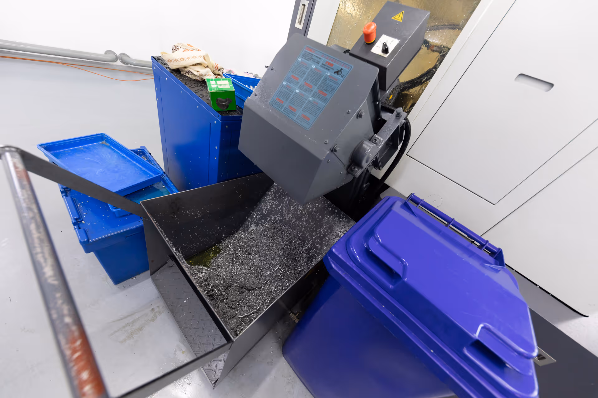 Industrial metal shredding machine with collection bins for scrap metal waste