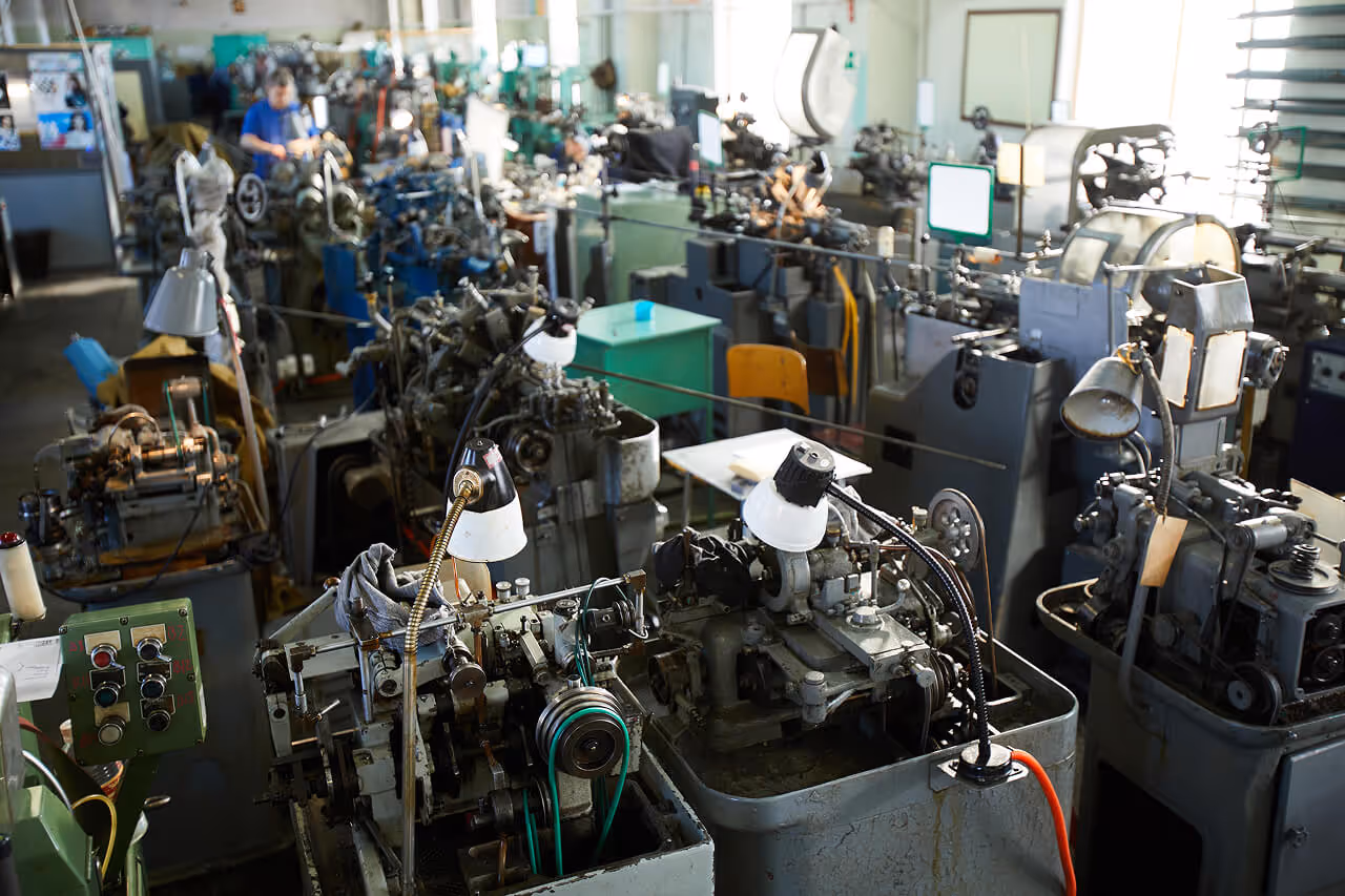 Wide view of a busy manufacturing workshop filled with rows of mechanical machinery and equipment