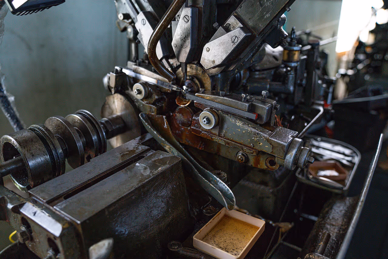 Close-up of a heavy industrial metalworking machine and mechanical parts in a production factory